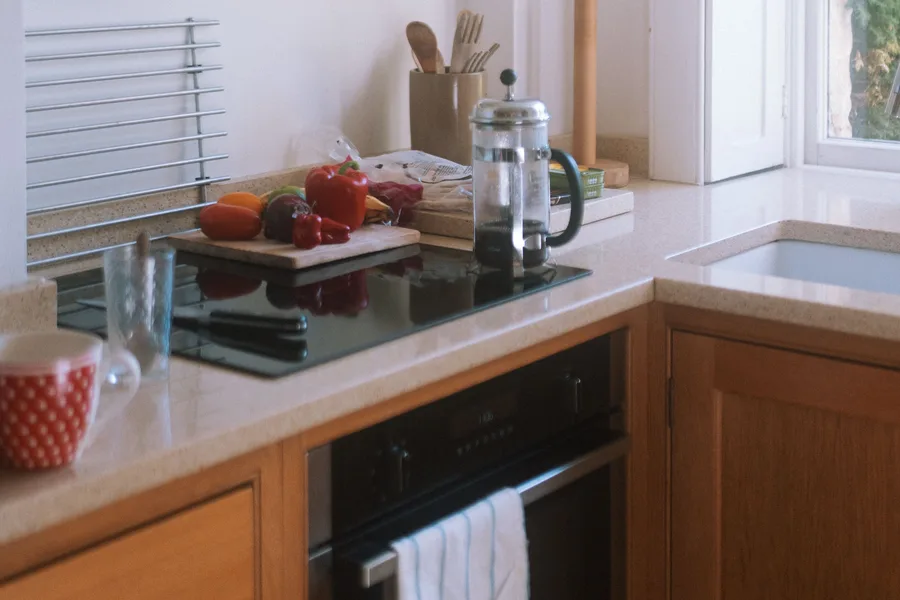 Kitchen counter with peppers, a French press and wood cabinets